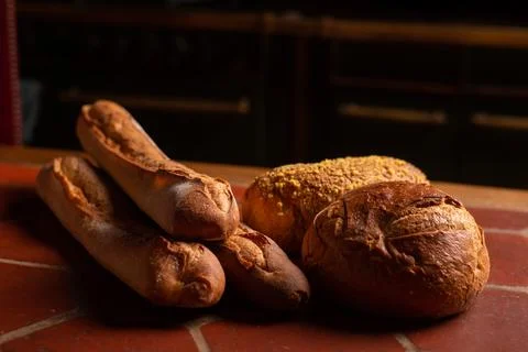 Different types of french bread on the table. Baguettes, round bread with b.. Stock Photos