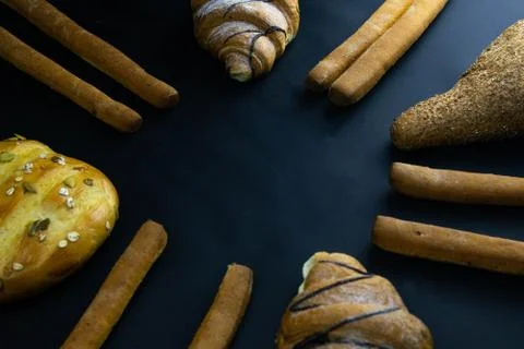 Different types of fresh bread with grain on a black rustic background. the b Stock Photos