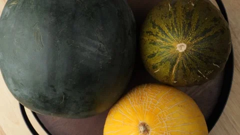 Different types of fresh melons rotating on a tray Vidéo 344604472
