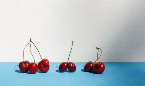 Different types of funny cherries with ugly growths, fused, on a blue background Stock Photos