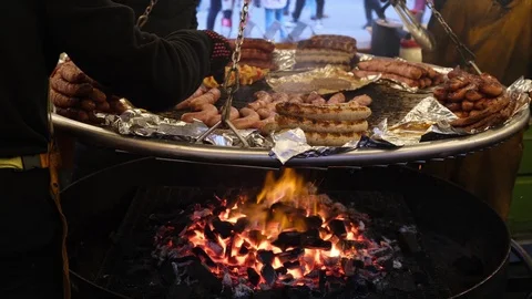 Different types of grilled sausages are fried in a huge pan over an open fire Stock-Footage 124114673