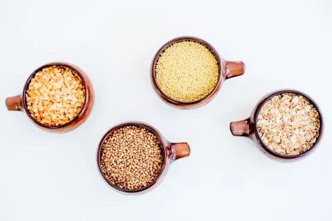 Different types of groats in pots on a white background Stock Photos