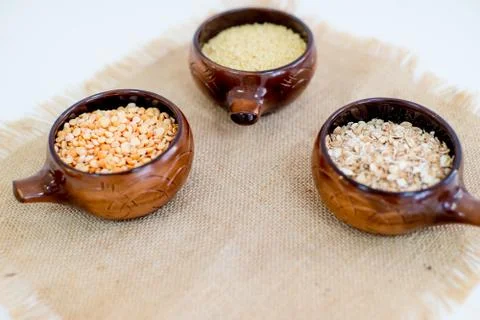 Different types of groats in pots on a white background Stock Photos