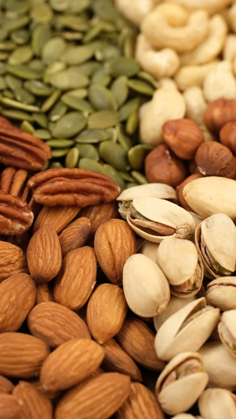 Different types healthy snack nuts and pumpkin seeds top view, rotation Stock Footage 312683203
