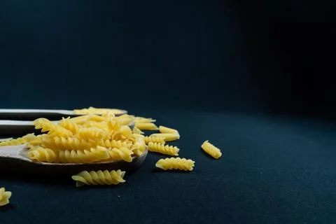 Different types of Italian pasta in spoon on the black background Stock Photos