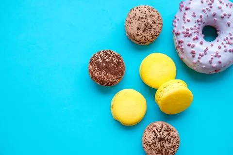 Different types of macaroons, donuts on blue candy background.Colorful and tasty Stock Photos