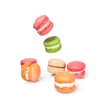 Different types of macaroons in motion falling or flying on white background. Stock Photos