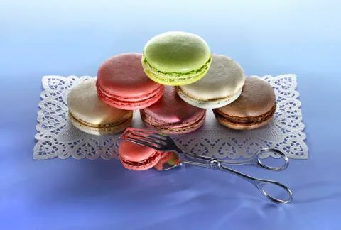 Different types of macaroons, stacked, on a cake paper placemat Stock Photos