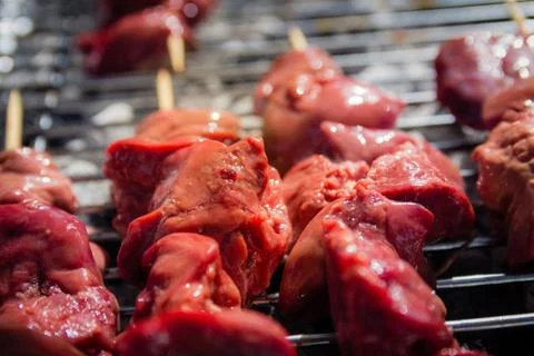 Different types of meat are cooked on the grill. Stock Photos