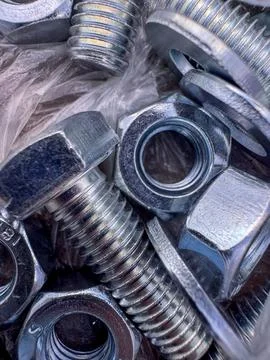 Different types of nuts and bolts arranged in a pile for hardware use Stock Photos
