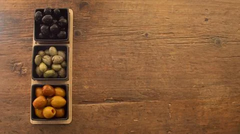 Different types of olives in three square black containers Stock Photos
