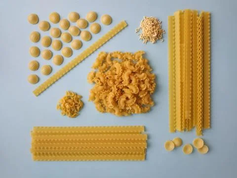 Different types of pasta, blue background. Food knolling, top view. Stock Photos
