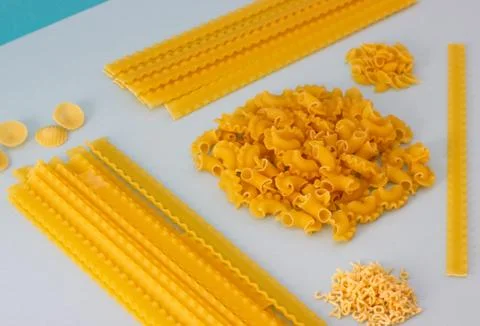 Different types of pasta, blue background. Stock Photos