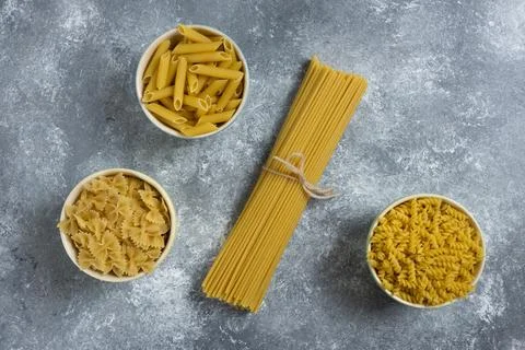 Different types of pasta on a gray background Stock Photos