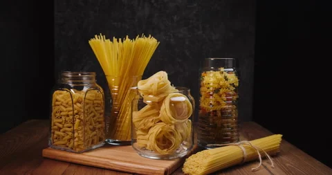 Different types of pasta on the table. On a black background. Vídeo Stock 154957302