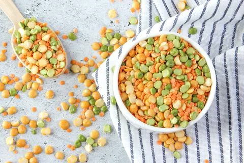 Different types of peas yellow and green in white bowl on grey stone background Stock Photos