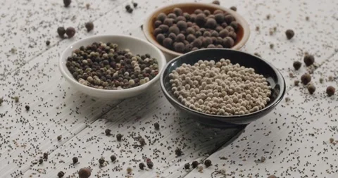 Different types of peppercorn spice falling on a table Stock Footage 344321814