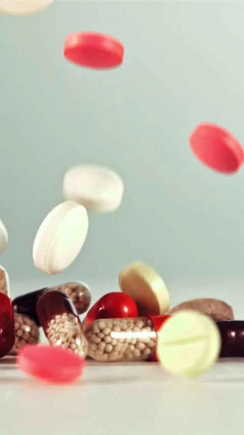 Different types of pills fall on the table. Filmed on a high-speed camera at Stock Footage 335291756