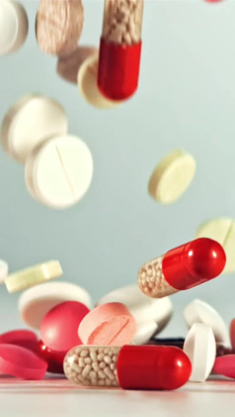 Different types of pills fall on the table. Filmed on a high-speed camera at Stock Footage 335293058