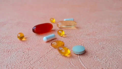 Different types of pills. Female hand takes a big golden one. Stock Footage 103857441