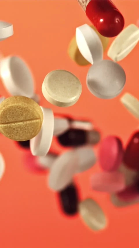 Different types of pills fly up and fall down. Filmed on a high-speed camera at Stock Footage 335293155