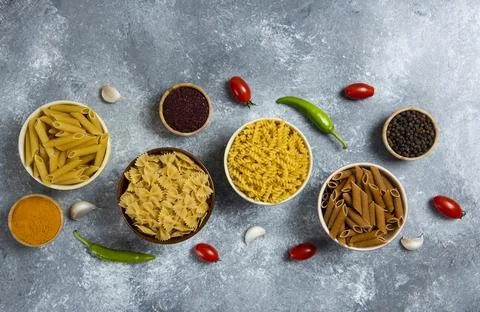 Different types of raw macaroni and vegetables Stock Photos