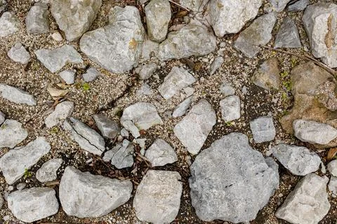 Different types of rocks and stones scattered on the ground in an outdoor a.. Stock Photos
