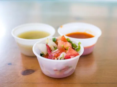 Different types of salsa in plastic cups Stock Photos