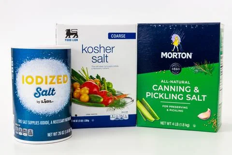 Different types of salt including iodized, kosher, and canning salt displayed on Stock Photos