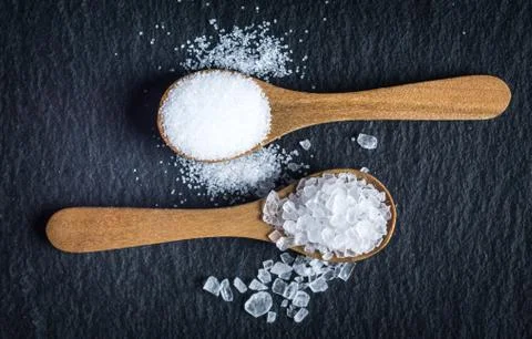 Different types of salt. Top view on two wooden spoons Stock Photos