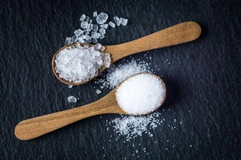 Different types of salt. Top view on two wooden spoons Stock Photos
