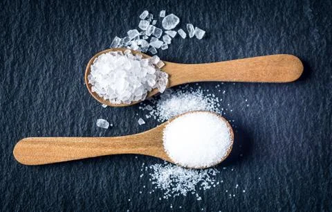 Different types of salt. Top view on two wooden spoons Stock Photos