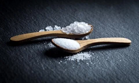 Different types of salt. Top view on two wooden spoons Stock Photos