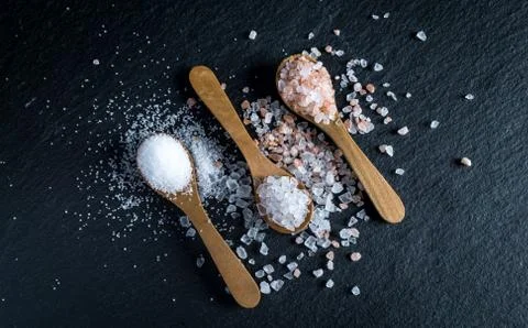 Different types of salt. Top view on three wooden spoons Stock Photos