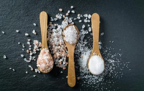 Different types of salt. Top view on three wooden spoons Stock Photos