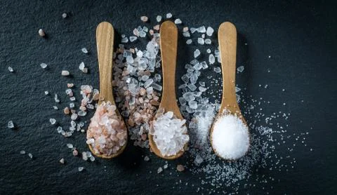 Different types of salt. Top view on three wooden spoons Stock Photos