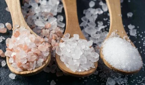 Different types of salt. Top view on three wooden spoons Stock Photos