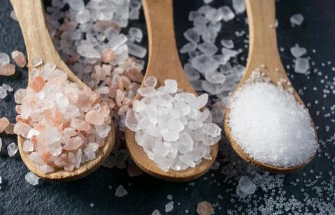 Different types of salt. Top view on three wooden spoons Stock Photos