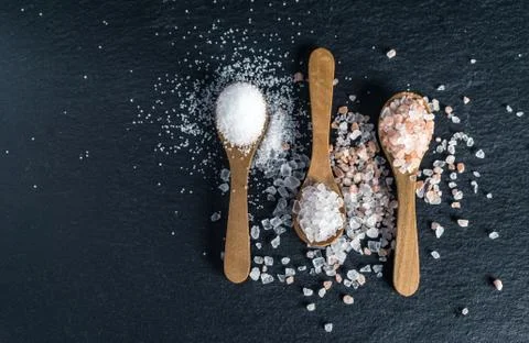 Different types of salt. Top view on three wooden spoons Stock Photos