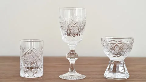 Different types of small elegant empty crystal glasses on the table Stock Footage 287916352