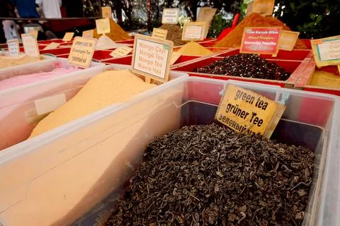 Different types of spices are arranged in wooden containers at a market. Labe Stock-Fotos