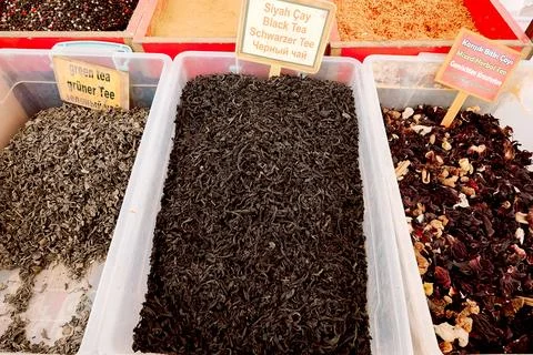 Different types of spices are arranged in wooden containers at a market. Labe Stock Photos