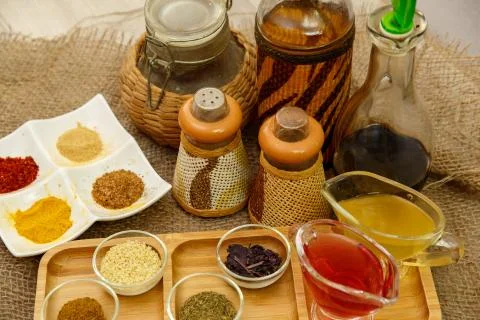Different types of spices in different containers on wood and canvas Stock Photos