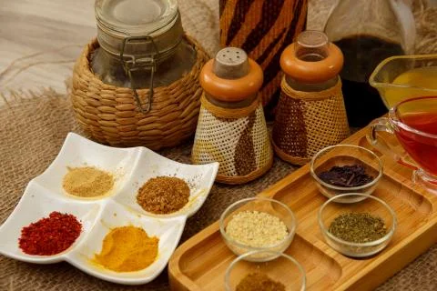 Different types of spices in different containers on wood and canvas Stock Photos