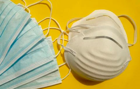 Different types of surgical disposable face masks on yellow background Stock Photos