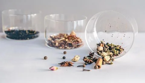 Different types of tea in glass jars on a light background, isolated. Fotos Stock