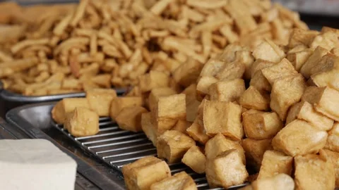 Different types of tofu displayed on trays at a market stall where soy based Stock Footage 330724704
