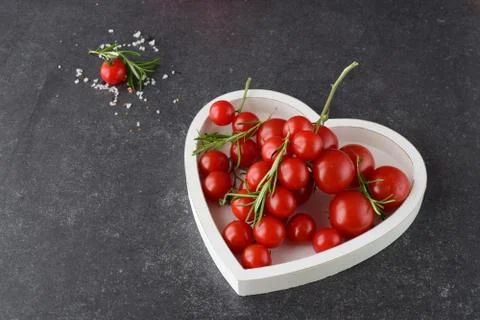 Different types of tomatoes on branches in heart shaped tray Stock Photos