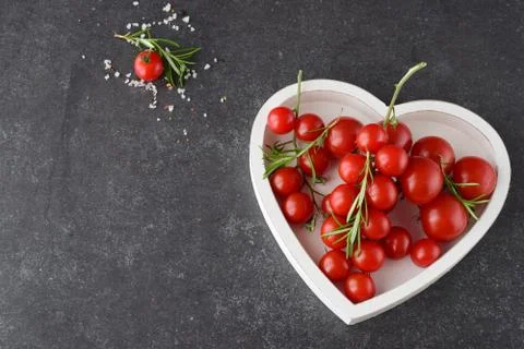 Different types of tomatoes on branches in heart shaped tray Stock Photos
