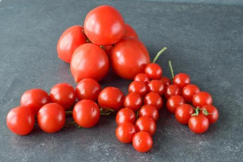 Different types of tomatoes on branches with rosemary and sea salt. Stock Photos